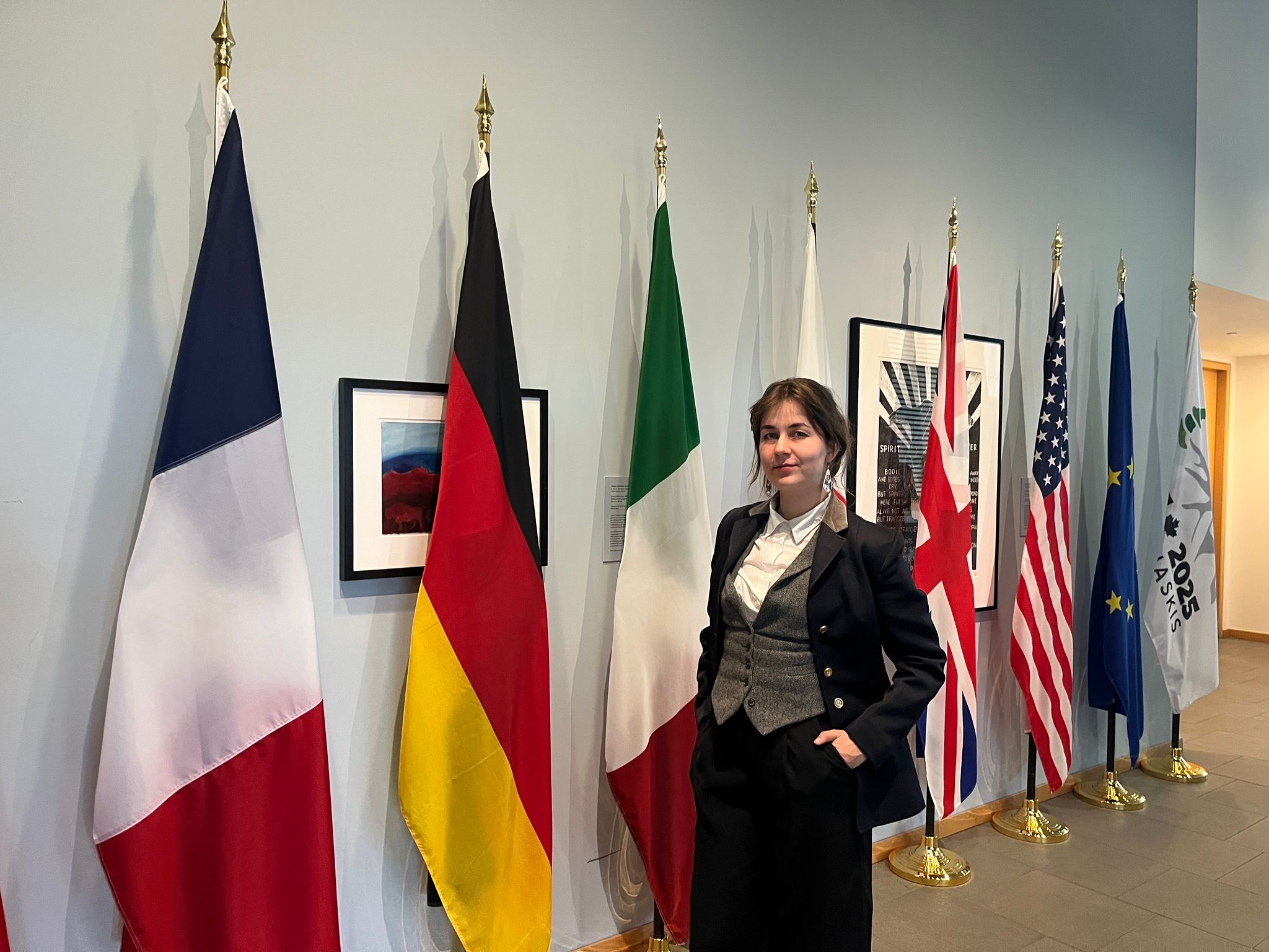 Jessica Rapson beside the national flags at the 2025 G7 Summit in Kananaskis, Canada